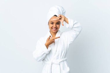 Bornozlu genç bir kadın izole edilmiş beyaz bir arkaplan, odaklanmış bir yüz. Çerçeve sembolü