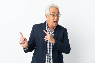 Beyaz arka planda izole edilmiş orta yaşlı Brezilyalı adam korkmuş ve kenarı işaret ediyor.