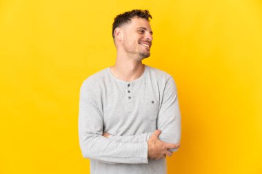 Sarı arka planda izole edilmiş beyaz, yakışıklı genç bir adam.