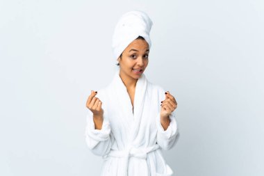 Bornozlu genç bir kadın soyutlanmış beyaz arka planda para hareketi yapıyor.