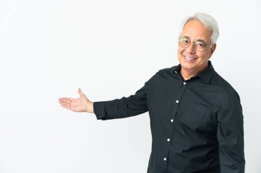 Orta yaşlı Brezilyalı bir adam beyaz arka planda izole edilmiş. Gelmesi için ellerini yana uzatıyor.