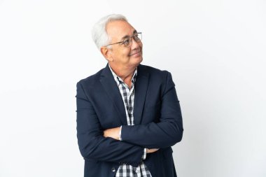 Orta yaşlı Brezilyalı adam beyaz arka planda izole edilmiş gülümserken yukarı bakıyor