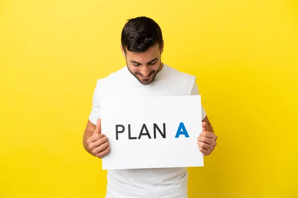 Young Handsome Caucasian Man Isolated Yellow Background Holding Placard Message — Stock Photo, Image