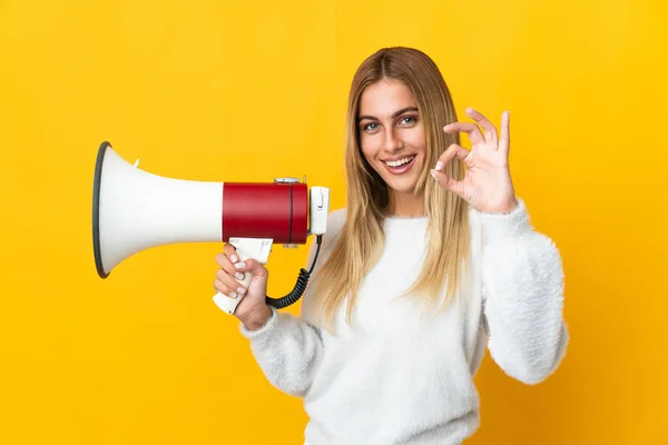 Jong Blond Vrouw Geïsoleerd Gele Achtergrond Met Een Megafoon Tonen — Stockfoto
