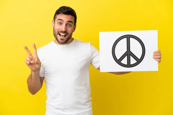 Young Handsome Caucasian Man Isolated Yellow Background Holding Placard Peace — Stock Photo, Image