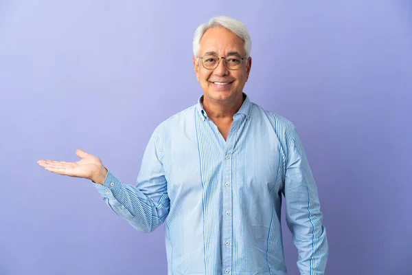 Homem Brasileiro Meia Idade Isolado Fundo Roxo Segurando Copyspace Imaginário — Fotografia de Stock