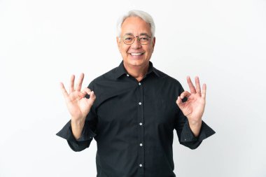 Beyaz arka planda izole edilmiş orta yaşlı Brezilyalı bir adam iki eliyle tamam işareti gösteriyor.