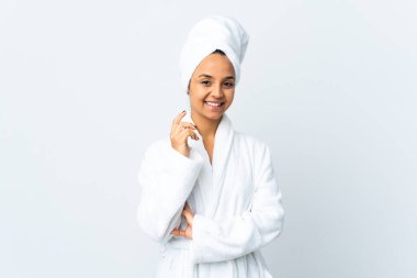 Bornozlu genç bir kadın soyutlanmış beyaz arka planda gülüyor.