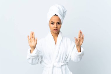 Bornozlu genç bir kadın izole edilmiş beyaz arka planda durup jest yapıyor ve hayal kırıklığına uğruyor.