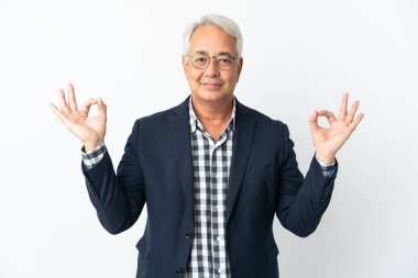 Orta yaşlı Brezilyalı erkek Zen pozunda beyaz arka planda izole edilmiş.