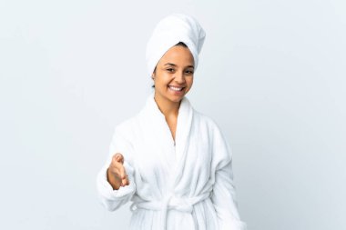 Bornozlu genç bir kadın izole edilmiş beyaz arka planda iyi bir anlaşma için el sıkışıyor.