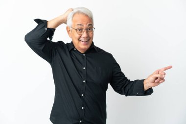 Beyaz arka planda izole edilmiş orta yaşlı Brezilyalı adam şaşırmış ve parmağıyla kenarı işaret ediyor.