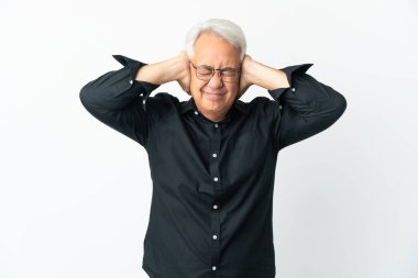 Beyaz arka planda izole edilmiş orta yaşlı Brezilyalı adam hayal kırıklığına uğramış ve kulaklarını kapatmış.