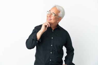 Orta yaşlı Brezilyalı adam beyaz arka planda izole edilmiş gülümserken yukarı bakıyor