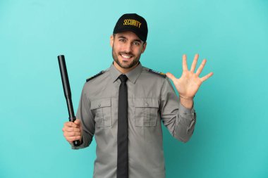 Mavi arka planda izole edilmiş genç güvenlik görevlisi parmaklarıyla beşi sayıyor.