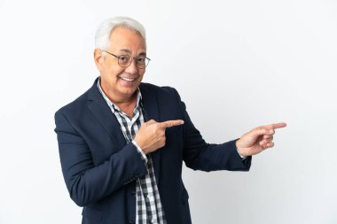 Beyaz arka planda izole edilmiş orta yaşlı Brezilyalı adam şaşırmış ve işaret ediyor.