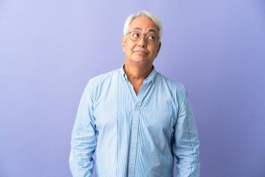 Orta yaşlı Brezilyalı bir adam mor arka planda izole edilmiş.