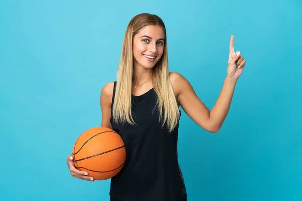 年轻女子打篮球时被白色背景隔离 露出并举起一个手指表示最好的标志 — 图库照片