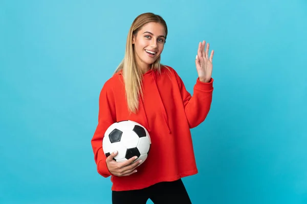 Jovem Jogador Futebol Mulher Isolado Fundo Azul Saudando Com Mão — Fotografia de Stock