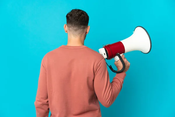 Young Caucasian Handsome Man Isolated Blue Background Holding Megaphone Back — Stock Photo, Image