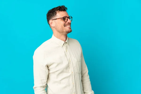 Young Caucasian Handsome Man Isolated Blue Background Looking Side Smiling — Stock Photo, Image