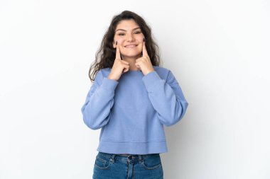 Beyaz arka planda izole edilmiş genç bir Rus kızı mutlu ve hoş bir ifadeyle gülümsüyor.