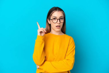 Kafkasyalı genç bir kadın mavi arka planda izole edilmiş.