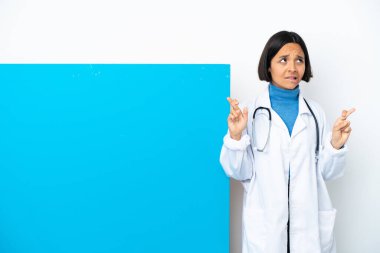 Beyaz arka planda izole edilmiş büyük bir pankartla genç melez bir doktor kadın.