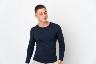 Beyaz arka planda izole edilmiş genç beyaz bir adam. Taraf ararken şüphe duyuyor.