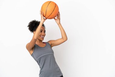Genç basketbolcu Latin kadın, beyaz arka planda izole edilmiş basketbol oynuyor.