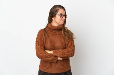 Orta yaşlı Brezilyalı bir kadın beyaz arka planda izole edilmiş, kollarını kavuşturuyor.