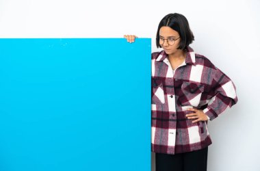 Beyaz arka planda izole edilmiş büyük mavi pankartlı melez bir kadın şüpheli davranışlar sergiliyor.