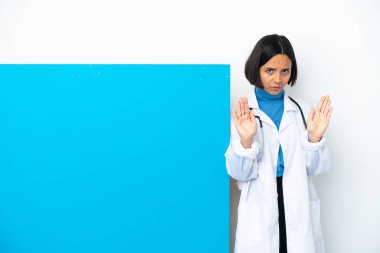 Beyaz arka planda izole edilmiş büyük bir pankartla genç melez doktor kadın dur hareketi yapıyor ve hayal kırıklığına uğruyor.