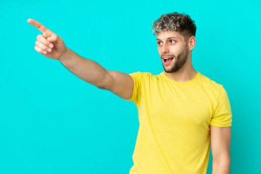 Mavi arka planda izole edilmiş yakışıklı beyaz bir adam.