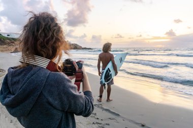 Kafkasyalı genç adam gün doğumunda sörf yapmak için erken kalkar.