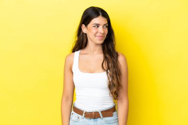 Sarı arka planda izole edilmiş beyaz bir kadın. Taraf ararken şüphe duyuyor.