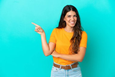 Mavi arka planda izole edilmiş genç, beyaz bir kadın var.