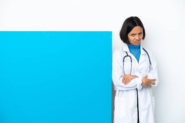 Beyaz arka planda, mutsuz bir ifadeyle izole edilmiş büyük bir afişi olan genç ırk doktoru kadın.