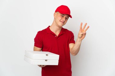 İş üniformalı bir pizzacı beyaz arka planda izole edilmiş pizza kutuları alıyor mutlu ve parmakları olan üç kişi sayıyor.