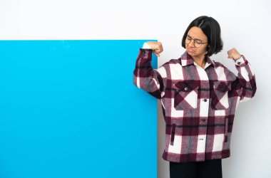 Beyaz arka planda izole edilmiş büyük mavi pankartlı melez bir kadın güçlü bir jest yapıyor.