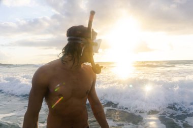 Genç, beyaz bir adam denizlere dalıp deniz türleri arıyor.