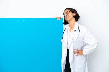 Beyaz arka planda, büyük bir afişi olan genç, melez bir doktor kadın gayret gösterdiği için sırt ağrısı çekiyor.