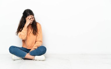 Genç Rus kız yerde oturmuş gülüyor.