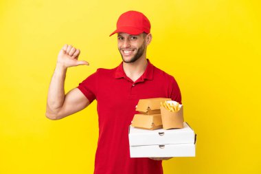 Pizza teslimatçısı, izole edilmiş arka planda pizza kutularını ve burgerleri topluyor gururlu ve kendini beğenmiş.