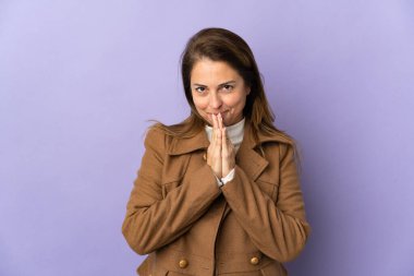 Mor arka planda izole edilmiş orta yaşlı Brezilyalı kadın avuç içlerini bir arada tutuyor. İnsan bir şey ister.