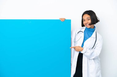 Beyaz arka planda izole edilmiş büyük bir pankartla genç, melez, ırk doktoru bir kadın parmak göstererek bir ürün sunuyor.