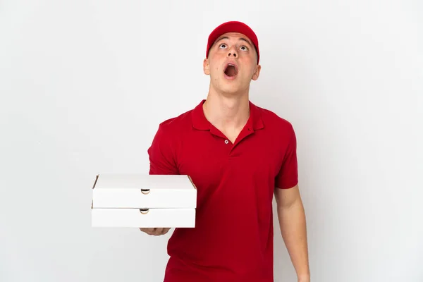ピザ配達男ともに仕事の制服ピザボックスを拾う隔離された白い背景上を見上げととともに驚きの表情 — ストック写真