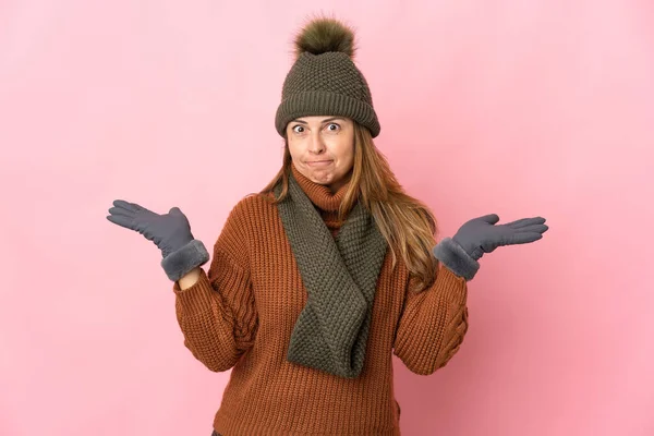 Medelålders Kvinna Med Vinter Hatt Isolerad Rosa Bakgrund Med Tvivel — Stockfoto