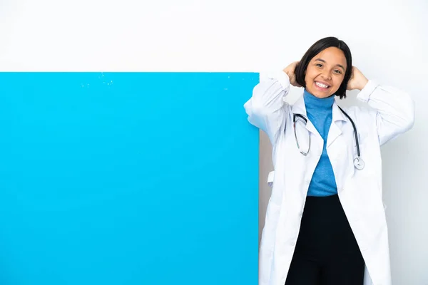 年轻的混合种族医生女人 有一个很大的标语牌孤立在白色的背景笑着 — 图库照片