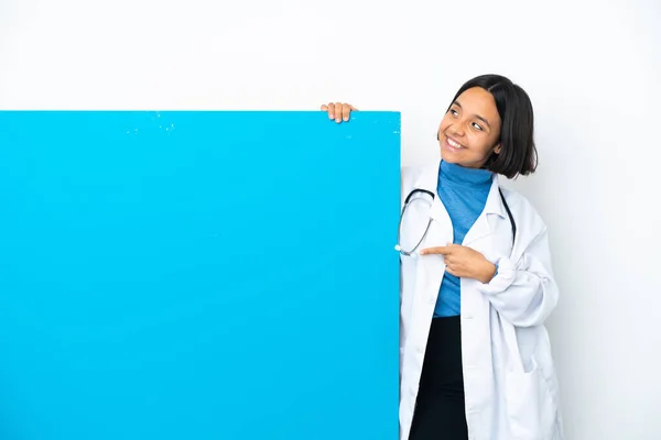 一个年轻的混合种族的医生女人 有一个白色背景的大海报 指出了一个伟大的想法 — 图库照片